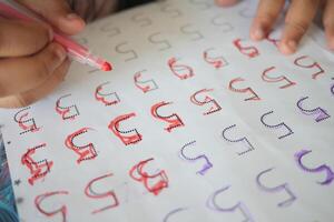 Learning to write letters with colored markers in a classroom setting photo