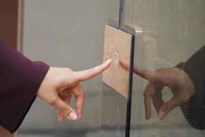 Person pressing elevator button in a modern building lobby photo