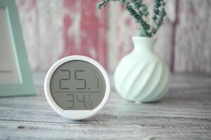 Temperature and humidity display on a wooden table with decor photo