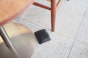Wallet found on the floor near a table in a casual setting photo