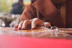 Hand reaching for a menu at a cafe on a sunny afternoon photo