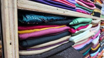 Colorful fabric rolls displayed in a textile shop in a busy market photo