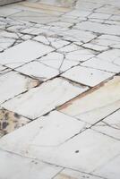 Old cracked marble flooring with distinct patterns in a quiet setting photo