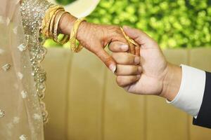 Hands of a bride and groom clasped together, symbolizing unity at dusk photo