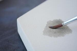 Artistic process on blank canvas with a brush applying paint photo