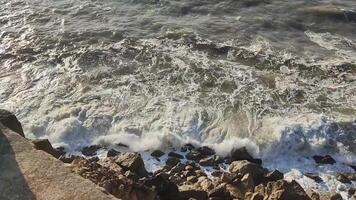 Turbulent sea meets rocky shore. Waves crash, creating white foam. Natures power on display, suitable for travel, environmental, or resilience themes. video