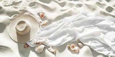 Elegant summer beach flat lay with white towel and straw hat on sandy shore photo