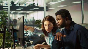 empregado e colega de trabalho olhando sobre receita figuras em pc dentro escritório. trabalho em equipe colegas focado em comparando companhia estatístico números, trabalhando Difícil para terminar trabalho antes prazo final, Câmera b video