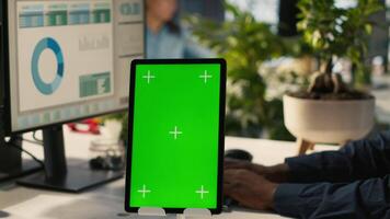 Close up of isolated screen tablet used by worker in office reviewing financial graphs. Employee looking over data trends and strategic insights on mockup tablet, analyzing KPIs, camera A video