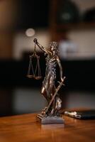 Lady justice statue is displayed on a wooden desk in a law office, symbolizing justice, fairness, and the legal system. Statue of Themis with a pair of scales of justice. Consulting a business client photo
