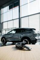 Tiny car model toy is placed on a table against dealership auto background. Premium car buying experience that combines expert guidance with high-class service in an elegant setting. Vertical shot photo
