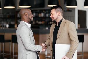 Black Manager two business men in meeting with laptop, coaching or learning in creative startup. Team, leader and discussion for brainstorming ideas, project update for event planning. Handshake, deal photo