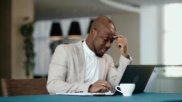 Tired African American businessman sleepy and bored from sitting at a desk for a long time and has office syndrome. Tired upset trader man of problem in business. Concept of stressful life, deadline photo