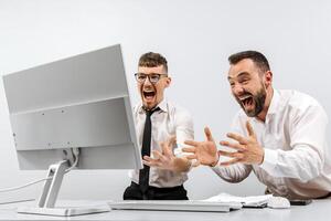 Two businessmen in the office rejoicing and showing enthusiasm for the work they have done. The concept of a successful online business and a successful startup photo
