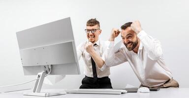 Two businessmen in the office rejoicing and showing enthusiasm for the work they have done. The concept of a online business and a successful startup. photo