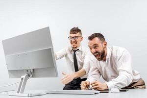 Two business men in the office rejoicing and showing enthusiasm for the work they have done. Successful online business and startup. The concept of winning and profits. Financial reward photo