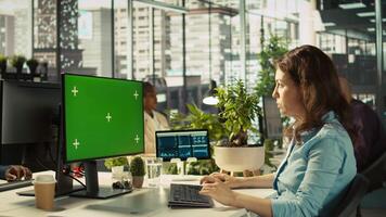 Green screen PC in office used by employee working on company administrative tasks. Mockup computer display on desk used by worker reviewing business data metrics, camera B video