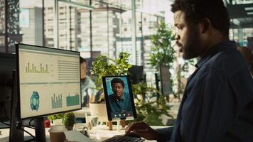 Worker in office talking with manager supervising tasks progression during online videocall. Employee discussing with supervisor overseeing work done during remote teleconference meeting, camera B video