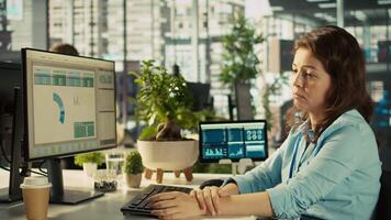 Stressed worker in office sighs, burdened by too many documents to review. Tired employee at work feeling overworked while analyzing business performance metrics, camera B video