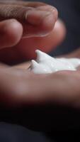 Hands applying cream to moisturize skin in close-up view video