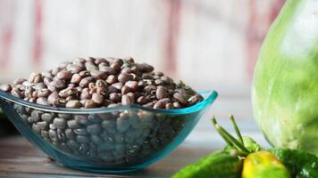 Fresh Green Vegetables and Bowl of Black Beans on Rustic Table video