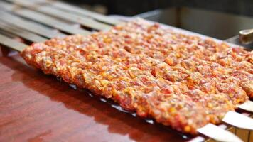 Grilling delicious skewers of marinated meat at outdoor market video