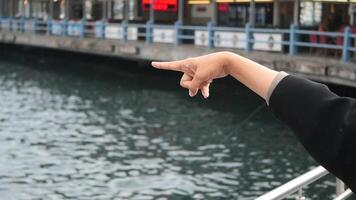 Person pointing at water while enjoying time near the dock video