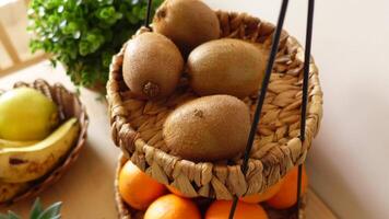 Fresh fruit display in a woven basket with kiwis and oranges video