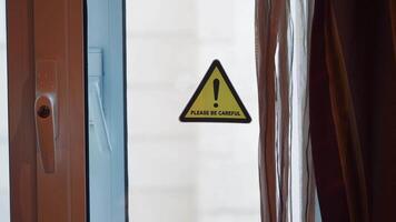 Warning sign for caution near a window in an indoor setting video