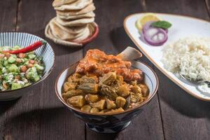 Stew Okra With meat Bamia served with rice, pita bread and salad isolated on wooden table side view of gourmet Middle Eastern stew photo