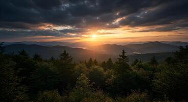 Mountainous vista at sunset with forested foreground and dramatic sky photo