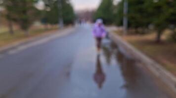 Blurred park stroll on a rainy day, person walking in motion video