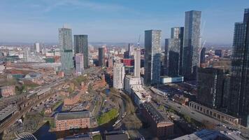 Aerial view of Manchester, UK, featuring skyscrapers like Beetham Tower, historic and modern architecture, railways, and canals under a clear sky. video