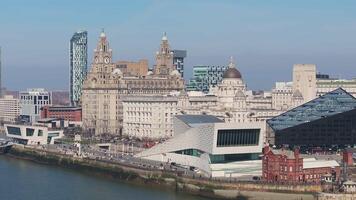 Aerial view of Liverpool's waterfront with a smooth pan showcasing the Royal Liver Building, Port of Liverpool Building, and River Mersey. video
