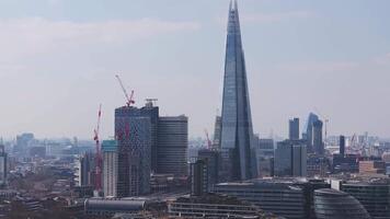 Aerial view of London with The Shard, Tower Bridge, and the River Thames. Smooth motion reveals the urban skyline blending modern and historic architecture. video