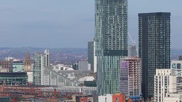 Aerial view of Manchester, UK, showing modern skyscrapers, historic architecture, construction cranes, and hills in the background with slow motion. video