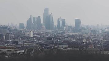 Aerial view of London's skyline under a cloudy sky, featuring the Shard, the London Eye, and St. Paul's Cathedral with cranes and ongoing construction. video