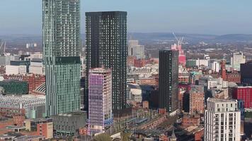 Aerial view of Manchester, UK, panning across modern and historic architecture, trains, and infrastructure with rolling hills in the background. video