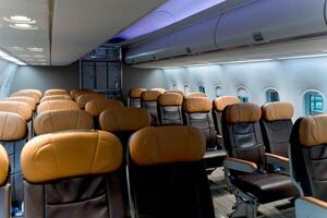 Interior of modern commercial airplane cabin with empty leather passenger seats arranged in rows, clean and organized for air travel comfort photo