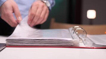 Office worker browsing through documents in a binder video