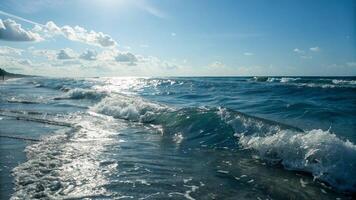 Waves crashing on the beach at sunset photo