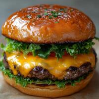 Juicy Cheeseburger with Melted Cheddar, Lettuce, and Sesame Seed Bun photo