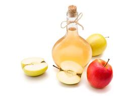 Homemade fermented apple vinegar in clear beautiful bottle with red and green apples. Healthy dietary food product with helpful bacterias, isolated on the white background. photo