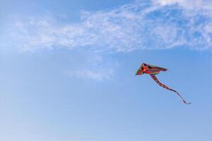 Rainbow kite flying in the blue sky photo