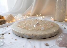 A round stone tray with a collection of small, clear and pink crystals, with a white cloth background and fairy lights photo