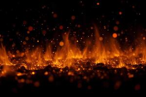 Fire flames with sparks on a black background, dark and bright, hot, inferno, hell, danger, warm colors photo