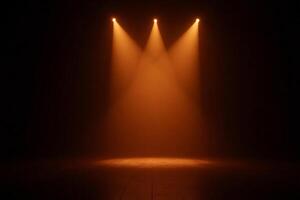 Three orange spotlights illuminating a dark stage, creating a dramatic effect with beams of light shining down, casting shadows and highlighting the texture of the floor photo