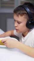 Adorable boy eating while watching movie on tablet video