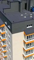 Außen von ein modern hoch erhebt euch Gebäude. Neu Wohnung Gebäude von zeitgenössisch Design mit groß Fenster und Balkone in der Nähe von Grün Bäume. Vertikale video