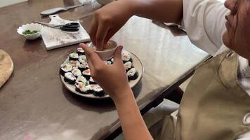 process of garnishing sushi rolls, artistry involved in creating visually appealing and delicious sushi at home with sesame seeds video